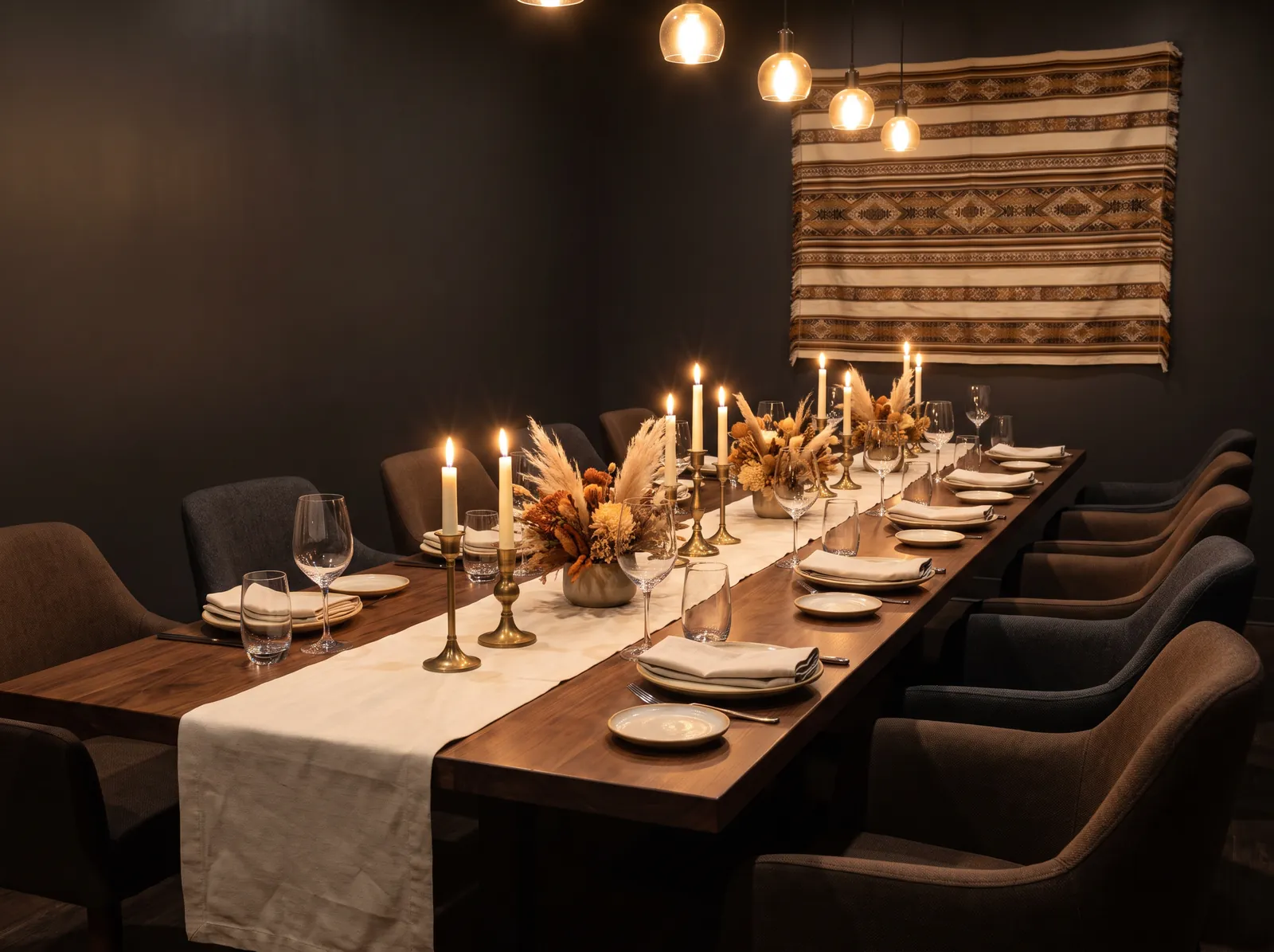 A long private dining table set for a group, lit by candles and pendant lights